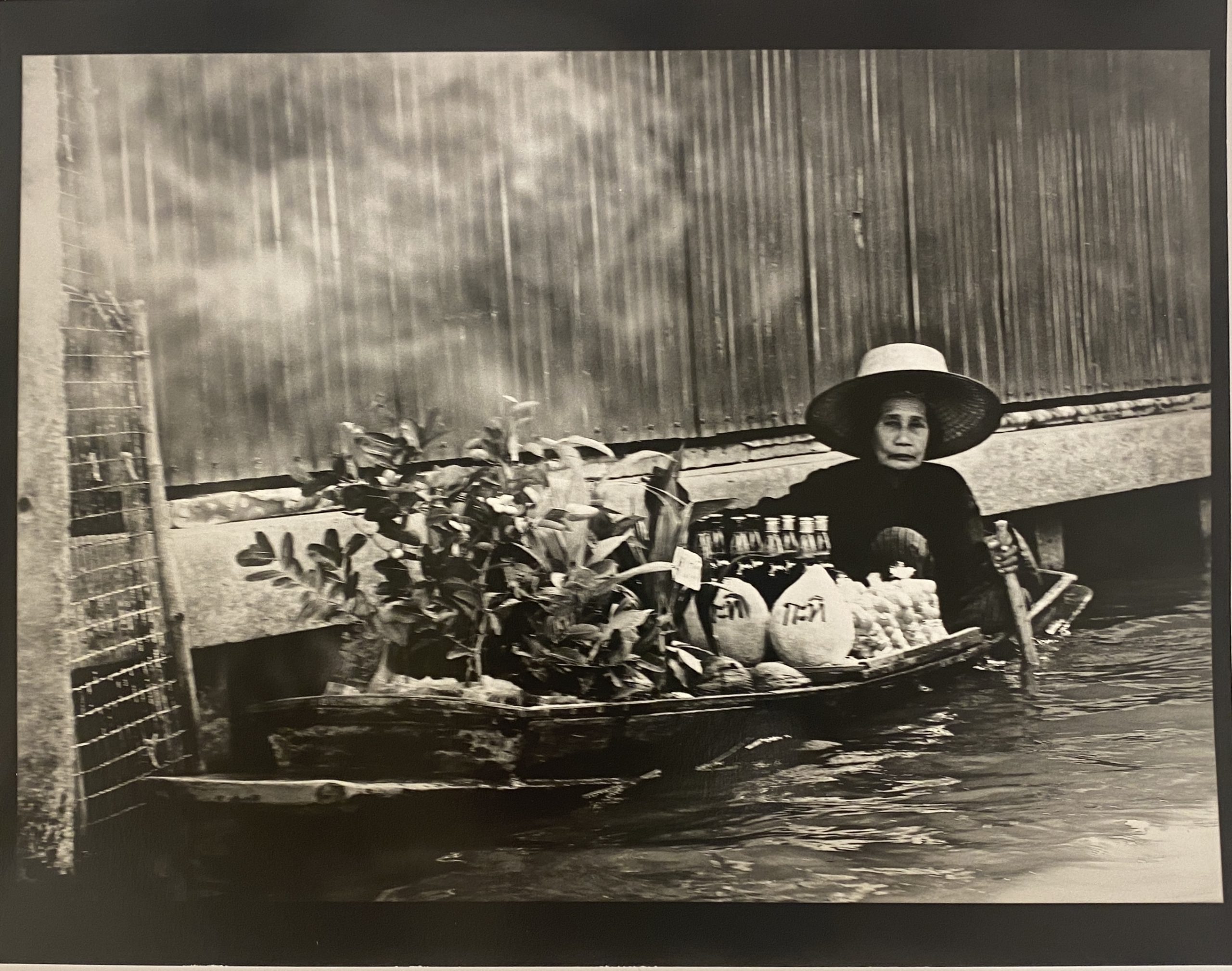 A woman in a boat with many items on it.